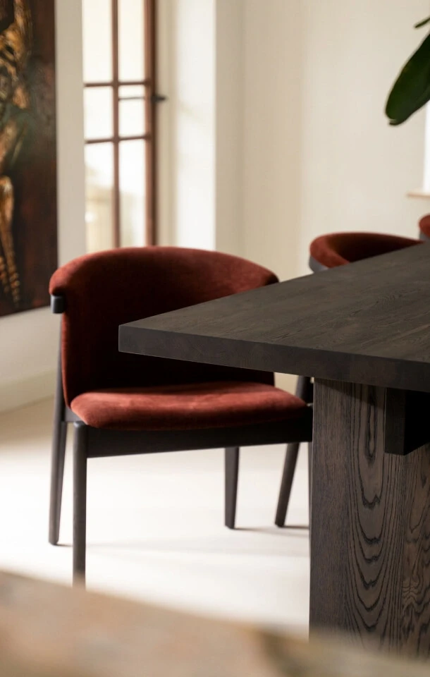 Rode eetkamerstoel Melzo met eikenhouten eettafel van Anne Claire collectie voor de woontrends van 2026.