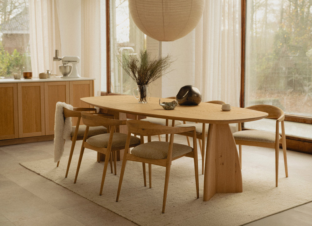 Woontrends van 2027 licht eikenhouten eetkamerset met houten keuken op de achtergrond