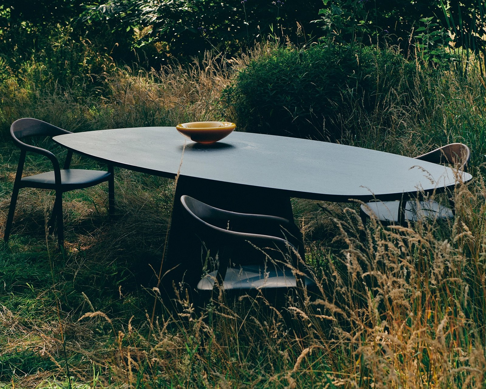 Ovale eettafel eikenhout met onderstel Eqone in tuin | Table du Sud